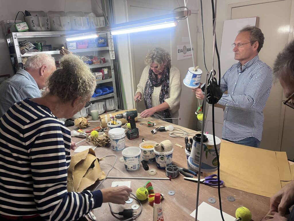 De werktafel vol materiaal, deelnemers aan het bouwen