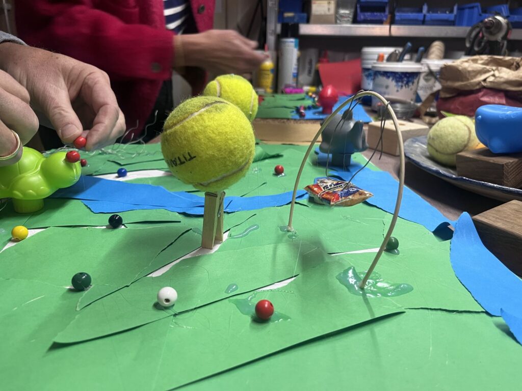 Detail van een kunstwerk met tennisballen en gekleurd papier