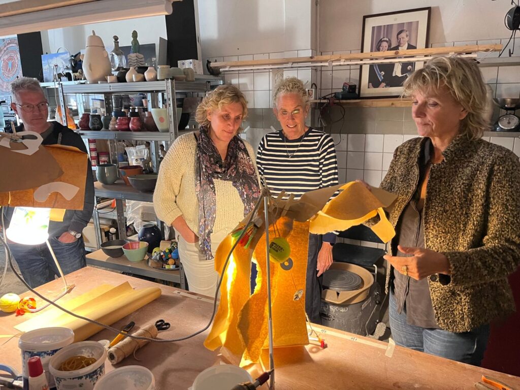 Deelnemers kijken samen naar de brandende lamp die ze hebben gebouwd